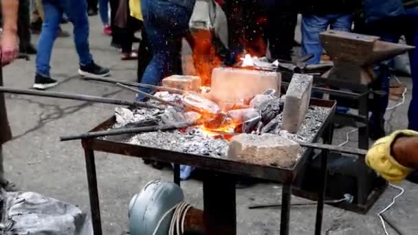 σιδεράς σφυρηλατεί μια μεταλλική λεπτομέρεια σε ένα αμόνι  - Πλάνα, βίντεο