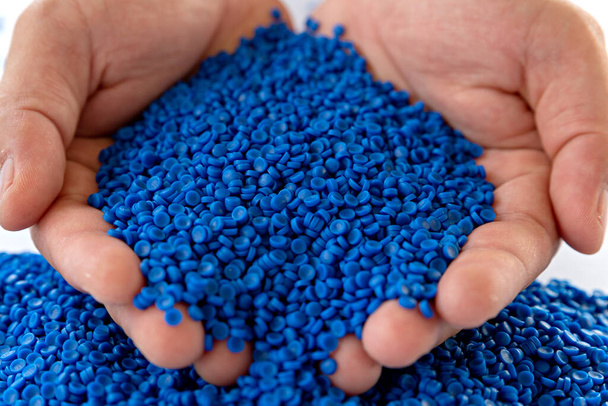 Blue plastic grain, plastic polymer granules,hand hold Polymer pellets, Raw materials for making water pipes, Plastics from petrochemicals and compound extrusion, resin from plant polyethylene. - Photo, Image