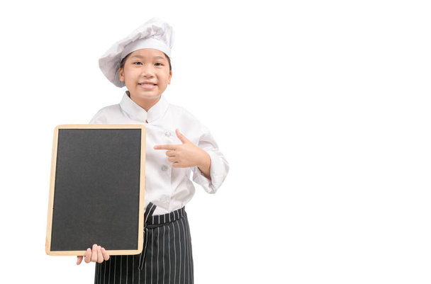Glückliche asiatische Köchin in Uniform zeigt auf leere Tafel isoliert auf weißem Hintergrund, Für Eingabetext oder Menü mit Kopierraum - Foto, Bild