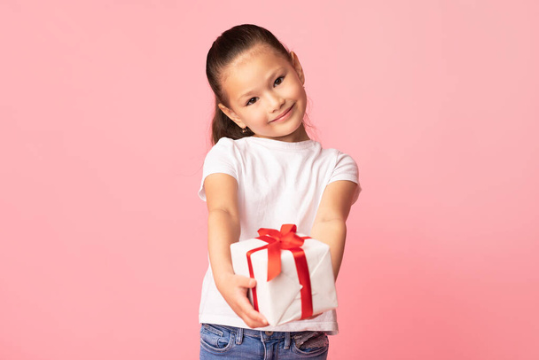 Счастливая девушка дарит тебе подарочную коробку в студии - Фото, изображение