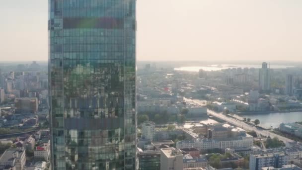 Top view of city reflected in windows of glass business skyscraper. Stock footage. Beautiful reflection of city in glass skyscraper on background city panorama on sunny day - Filmmaterial, Video