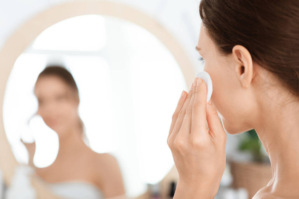 Primo piano di donna irriconoscibile pulizia del viso con lozione - Foto, immagini