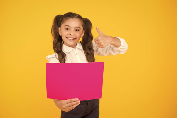Back to school concept. Upcoming event. Look here. Girl school uniform hold poster. Changes coming. Schoolgirl pupil show poster. Schoolgirl hold poster copy space. News information promotion - Foto, Imagen