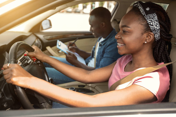 Chica africana tomando prueba de conducción con instructor profesional - Foto, imagen