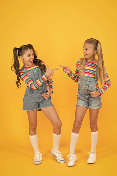 Looking trendy. hairdresser salon. kid summer fashion. beauty and style. childhood happiness. happy school friendship. best friends forever. small sisters have fun. little girls yellow background - Фото, изображение