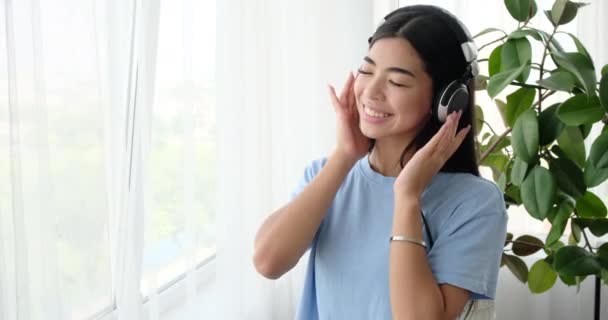 Γυναίκα ακούγοντας μουσική στα ακουστικά στο σπίτι - Πλάνα, βίντεο