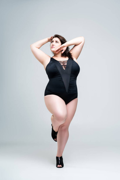 Sexy plus size fashion model in black one-piece swimsuit, fat woman in lingerie on gray background, body positive concept - Foto, Imagem