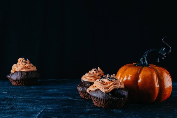  Chocolate cupcakes and pumpkin, halloween background concept - Foto, afbeelding