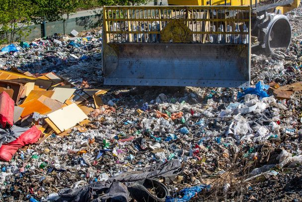 埋め立て廃棄物の中でゴミを処理するブルドーザー、世界の生態系の問題 - 写真・画像