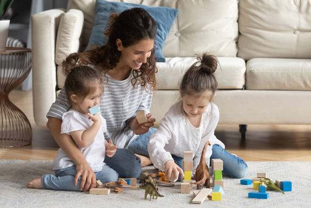 Smiling beautiful young mother enjoying playing with cute daughters indoors. - Φωτογραφία, εικόνα