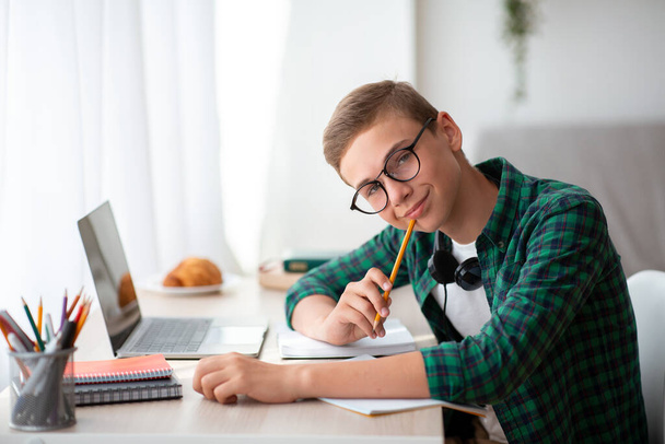 Smiling nerd guy enjoying his studying at home - Photo, Image