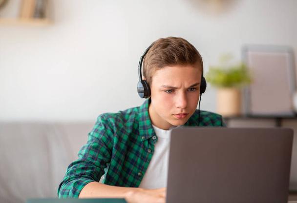 Closeup of concentrated schooler studying online from home - Photo, Image