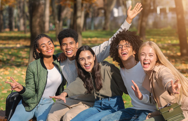 Emotional international group of teenagers posing at park - Valokuva, kuva
