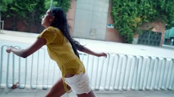 pretty athletic girl rides a longboard in modern city - Filmati, video