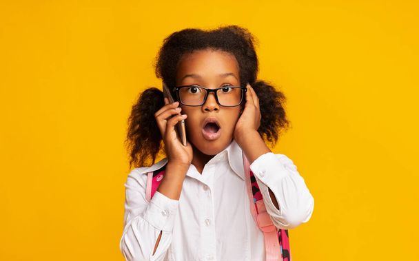 Shocked School Girl Talking On Phone With Opened Mouth, Studio - Fotó, kép