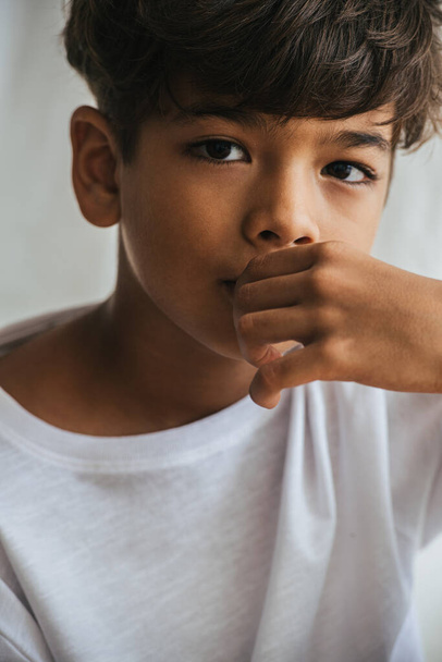 Portrait of an indian asian kid touching his mouth with hand. Close up. - Foto, afbeelding