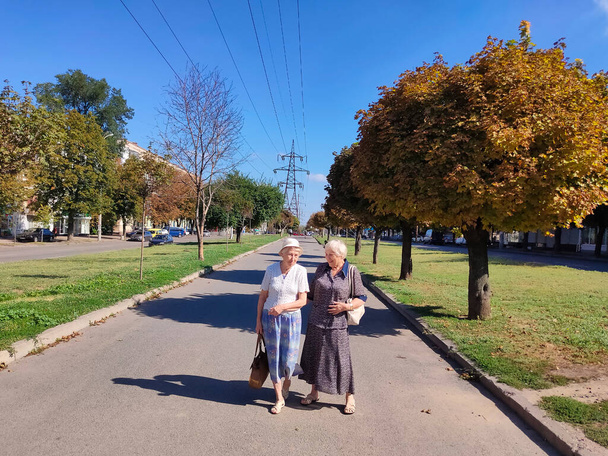 Şehir caddesinde ilerleyen iki son sınıf öğrencisi bayan. Yazın olgun kadınların manzarası - Fotoğraf, Görsel