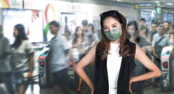 Smart asian woman model wearing face mask in public transrport station on urban city lifestyle to stay alive with pandemic - Foto, Bild