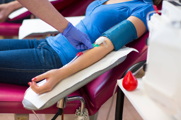 Young woman giving blood in a modern hospital (color toned image) - Foto, imagen