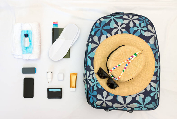 Knolling women travel set with mask, hand sanitiser, straw hat, sunglasses and accessories. - Photo, Image