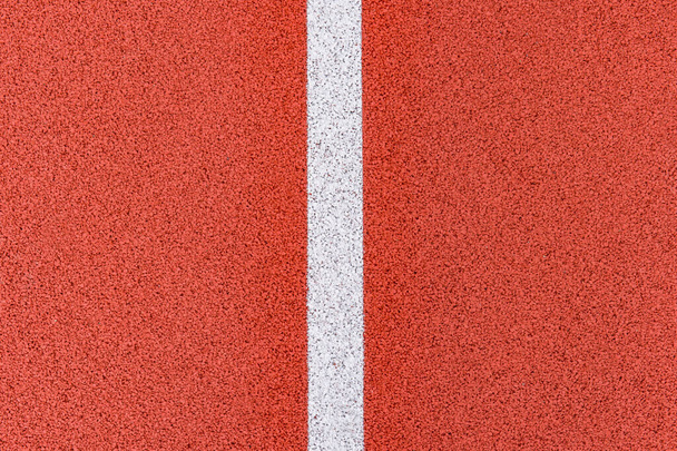Close up on a white line in artificial red turf, on a street basketball, handball, volleyball, futsal, rugby, hockey and football field, in a sports background - Photo, Image