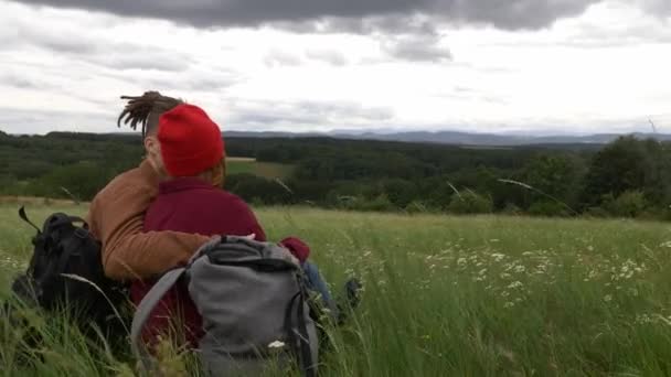 giovane coppia è rilassato sull'erba con vista sulle montagne - Filmati, video