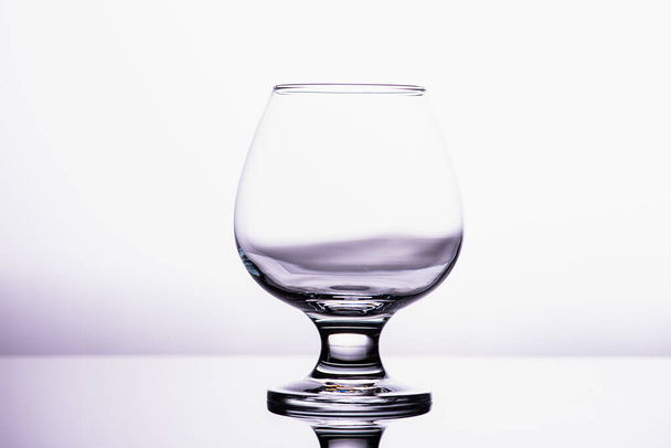beyaz zemin üzerinde izole edilmiş şeffaf bir cam konyak bardağı.  - Fotoğraf, Görsel