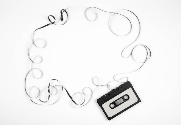 Cinta de casete analógica sobre fondo blanco, marco retro de los años 80, mucho espacio de copia vacío.  - Foto, imagen