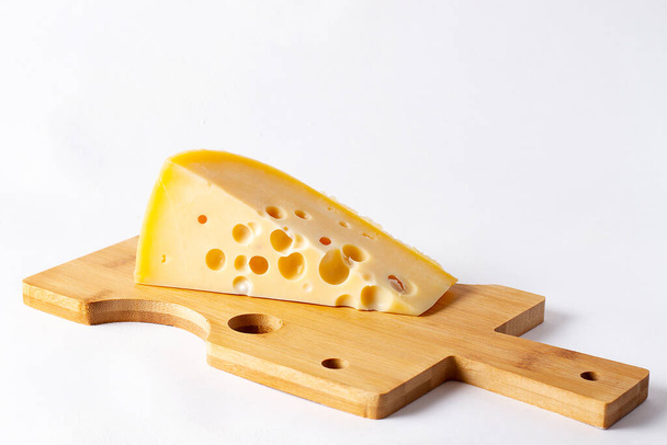 τρίγωνο τυριού οπής, πλακέτα κοπής τυριού, σε λευκό φόντο  - Φωτογραφία, εικόνα