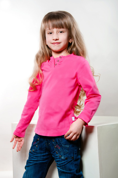 Little girl with long curly hair in a pink blouse - Fotó, kép