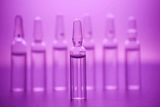 glass medicine ampoules on a pink background close up - Valokuva, kuva