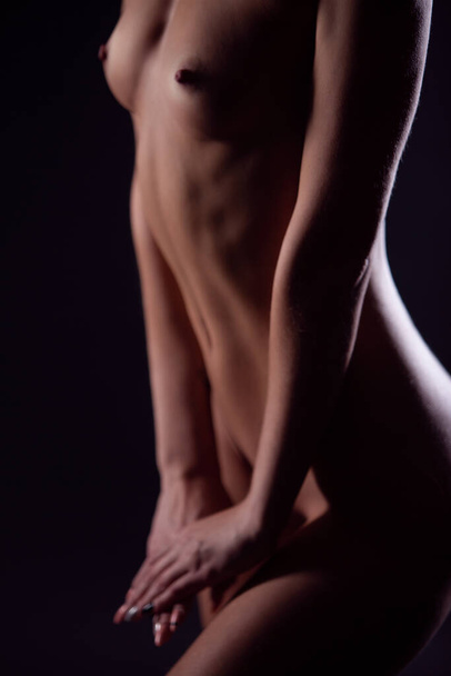 beautiful naked female body on black background - Foto, Imagen