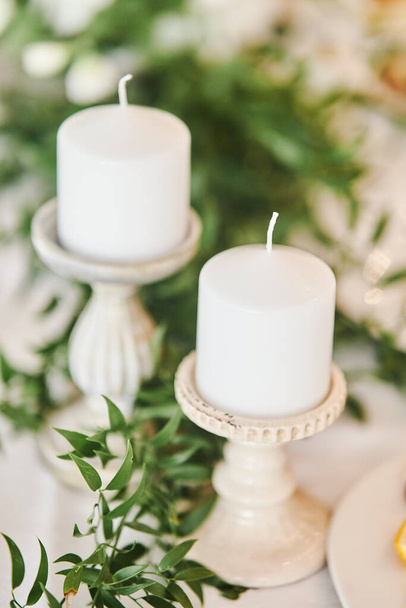 White candles in candlesticks at a wedding celebration - Foto, Imagem