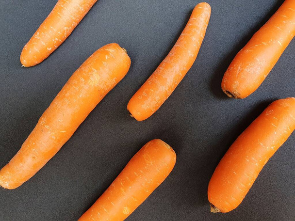 kawałki świeżej marchewki warzywnej na czarnej powierzchni, witamina A żywności - Zdjęcie, obraz