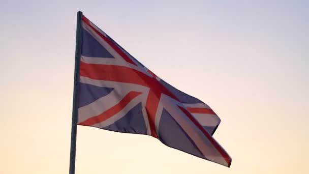 Britische Flagge weht über dem Himmel bei Sonnenuntergang. - Filmmaterial, Video