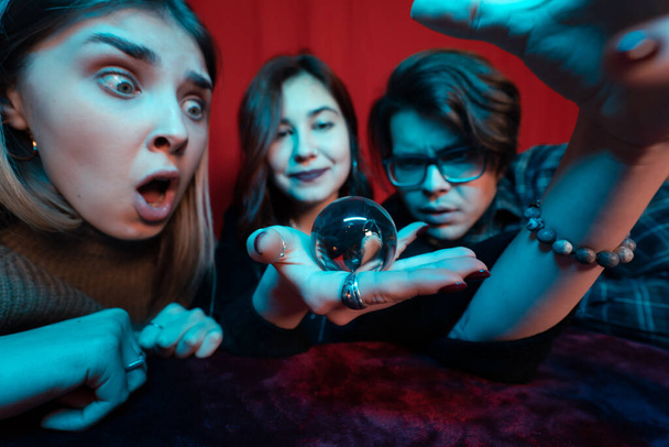 Group of people and woman fortune teller with crystal ball - Photo, Image