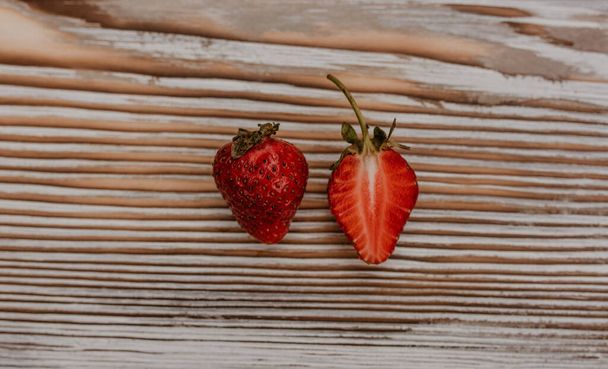 Šťavnaté červené jahody leží na dřevěné desce - Fotografie, Obrázek
