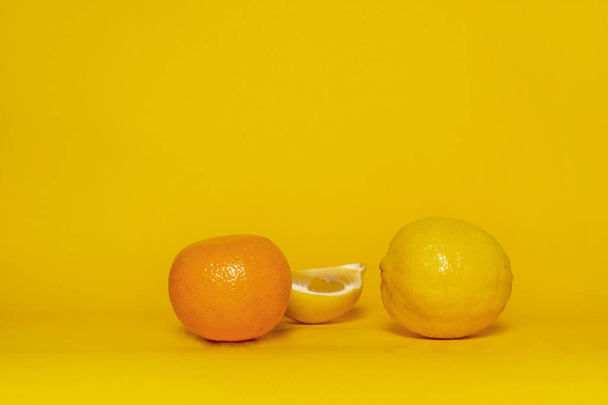 rodaja fresca de limón amarillo y naranja mandarina fruta para la comida sobre fondo colorido - Foto, Imagen