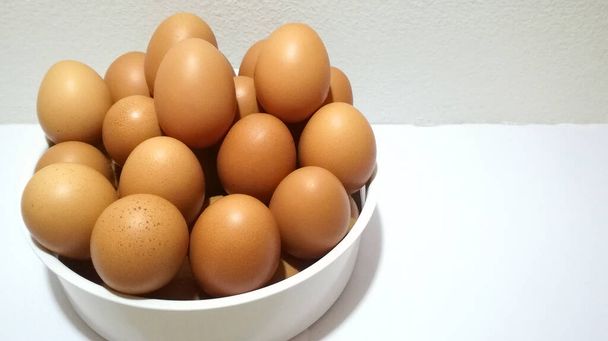 農場の卵は、薄明かりのあるプラスチック容器に入れられています。. - 写真・画像