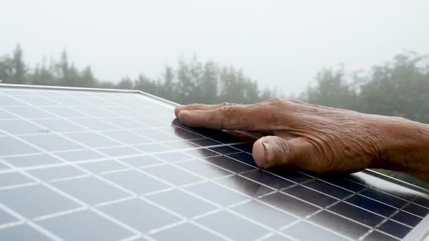 Close-up van de hand aanraken op zonnecel pad in mistige ochtend buiten. - Video