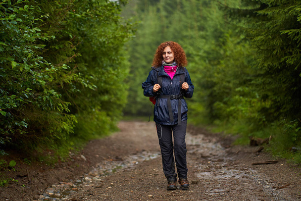 Backpacker Caucasian woman hiking in the mountains in a rainy day - Φωτογραφία, εικόνα