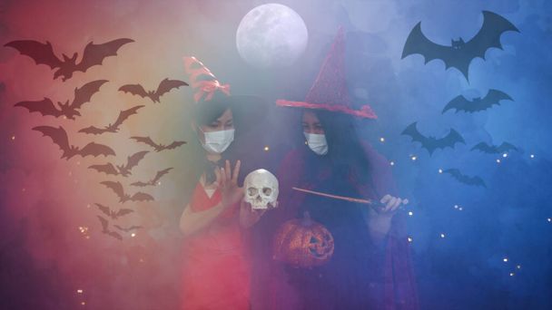 halloween portrait background of two asian woman in fancy party witch costume on foggy night background with bats shadow - Fotoğraf, Görsel