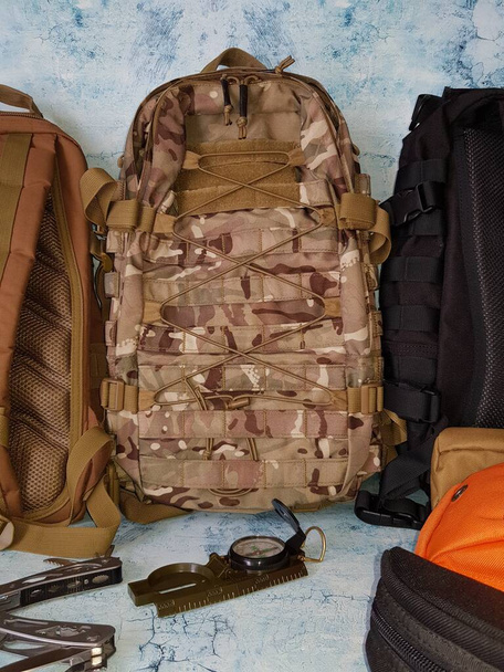 Compass and multitool lie near the backpack - Foto, Imagen