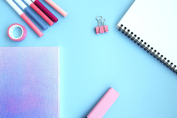 Neon notebook, scotch tape, watch, clips, eraser, open notepad and markers on a blue background with space for text. School stationery. Getting ready for school. Creative workspace. Flat lay - Photo, Image