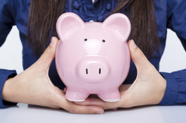 Close-up of a businesswoman holding a piggy bank - Foto, Imagen