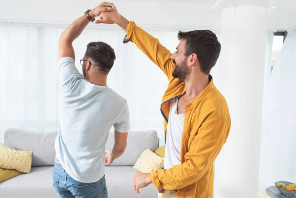 Gay couple dancing at home - 写真・画像