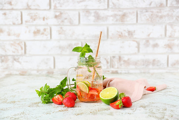 Mason jar of tasty strawberry mojito on table - Valokuva, kuva