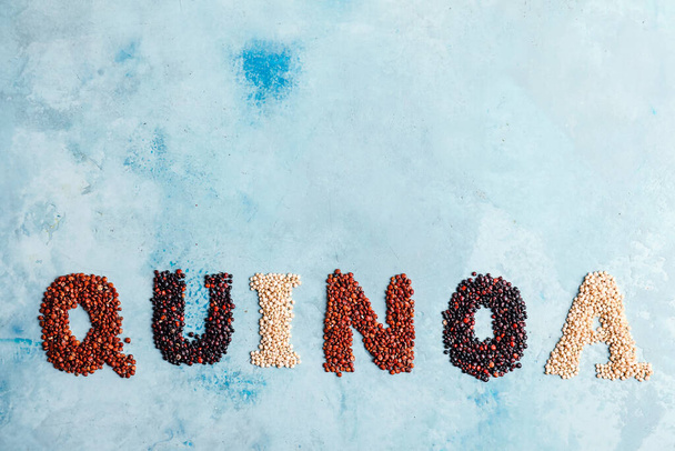 Woord QUINOA met zaden op kleur achtergrond - Foto, afbeelding