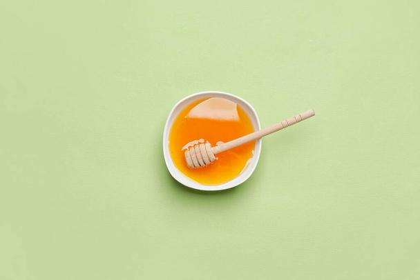 Bowl with honey on color background - Foto, afbeelding
