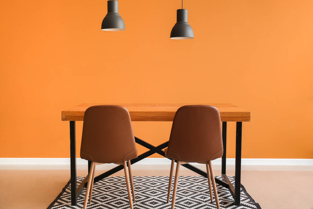 Dining table near color wall - Фото, зображення